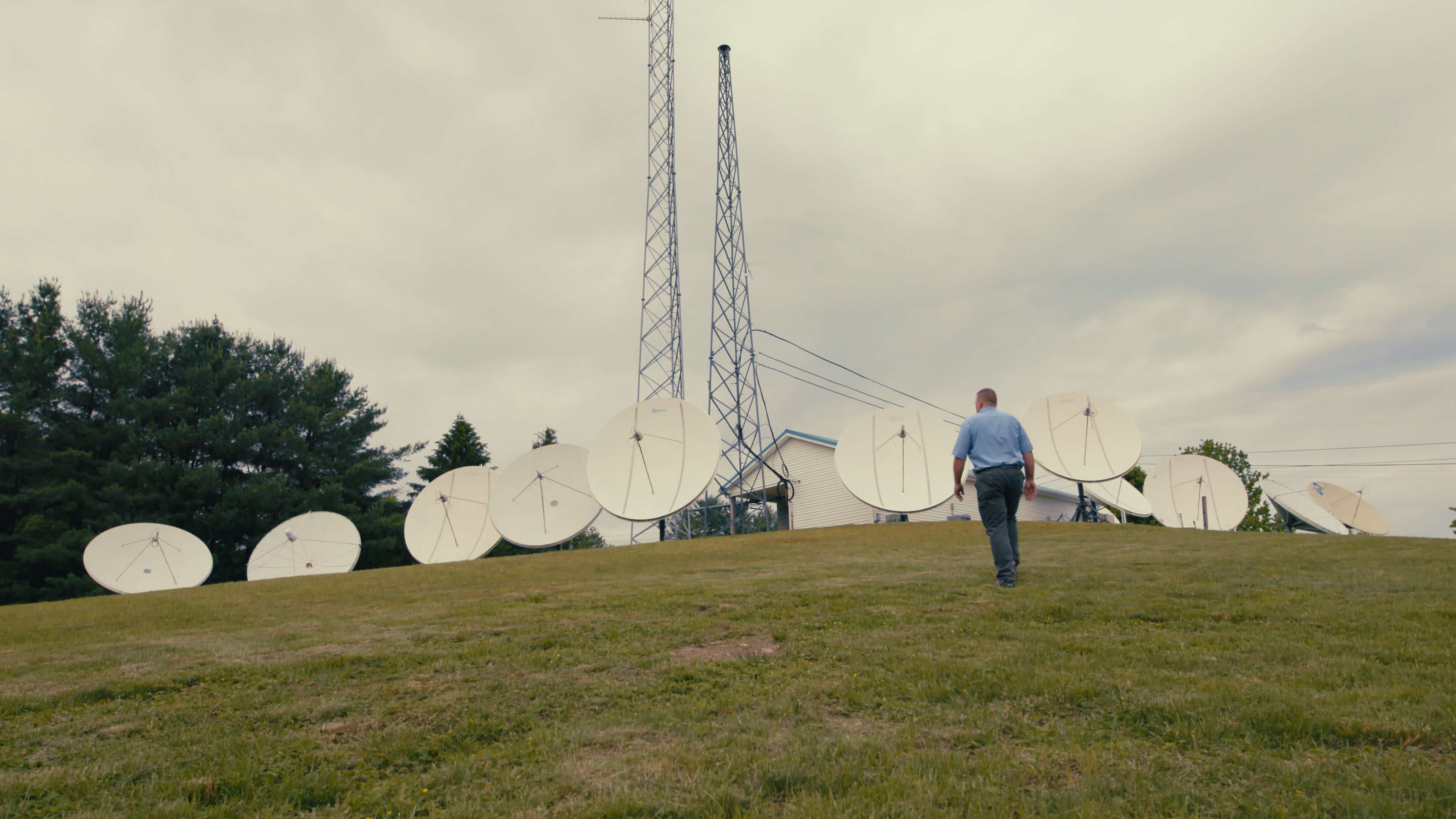 person walking towards a field of satellite dishes